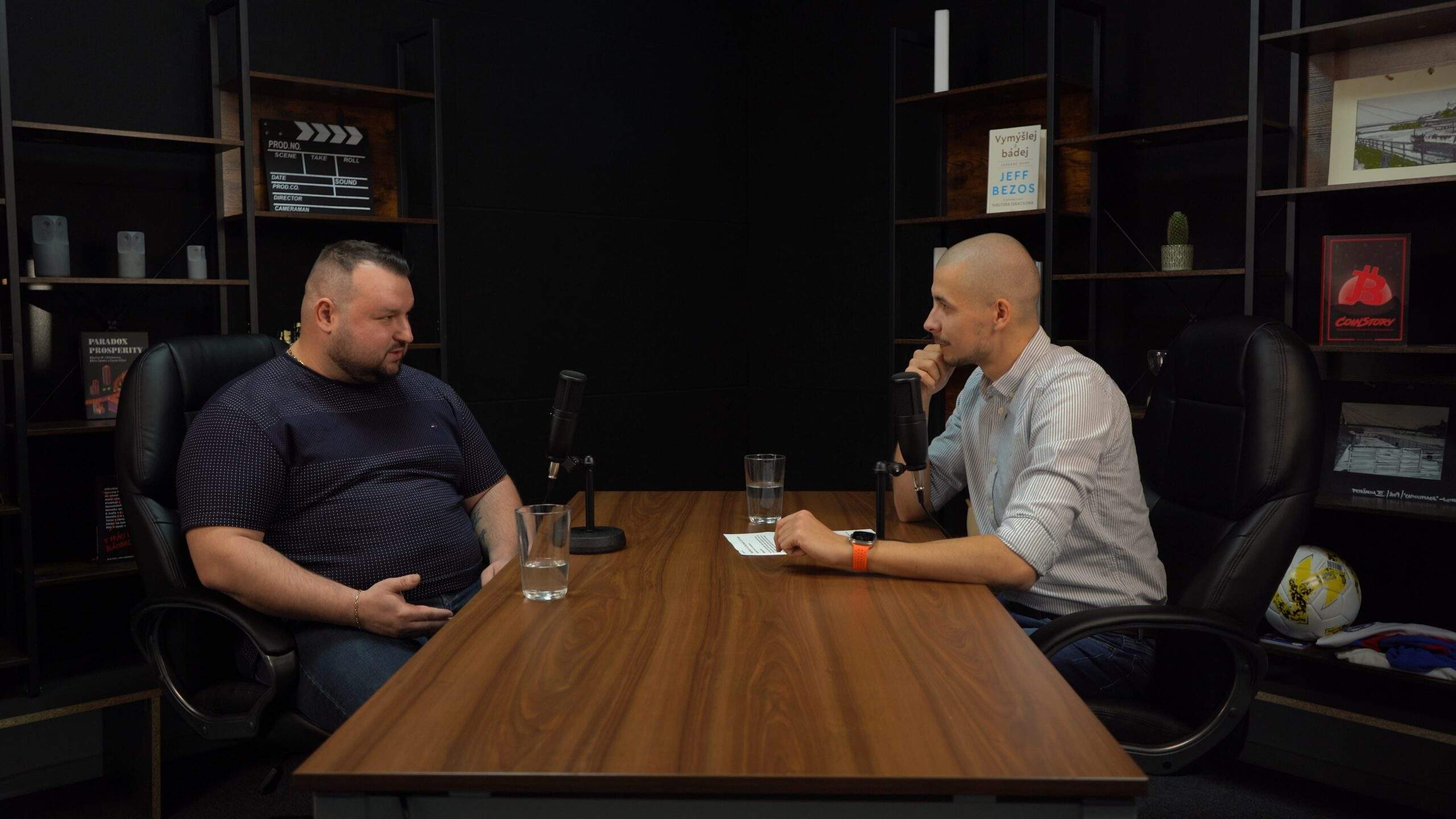Rozhovor v štúdiu – dvaja hostia pri nahrávaní podcastu za stolom s mikrofónmi